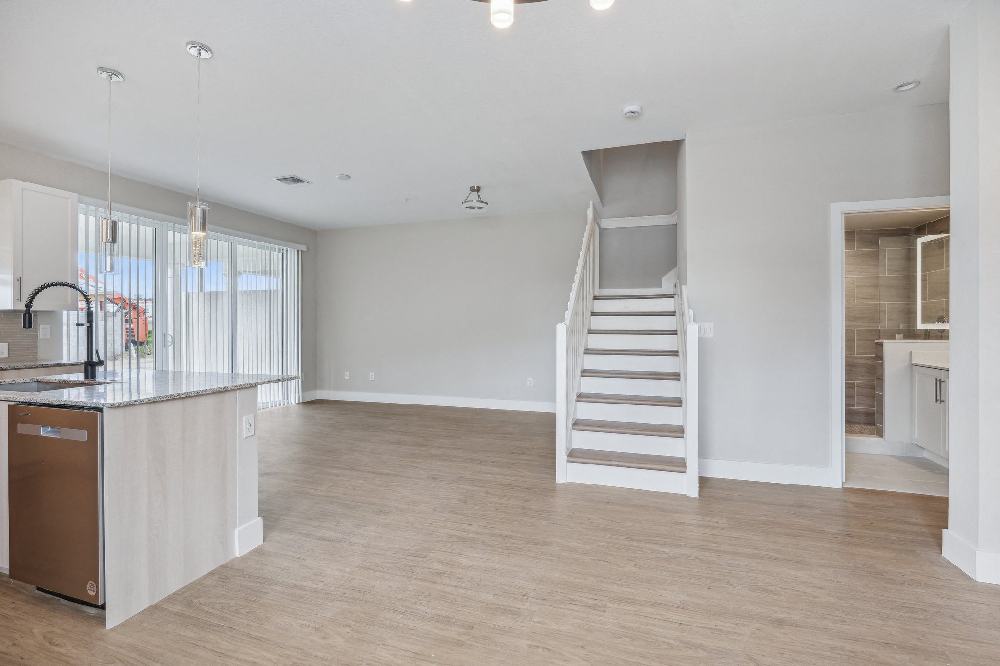 an open kitchen and living room with a staircase to a loft
